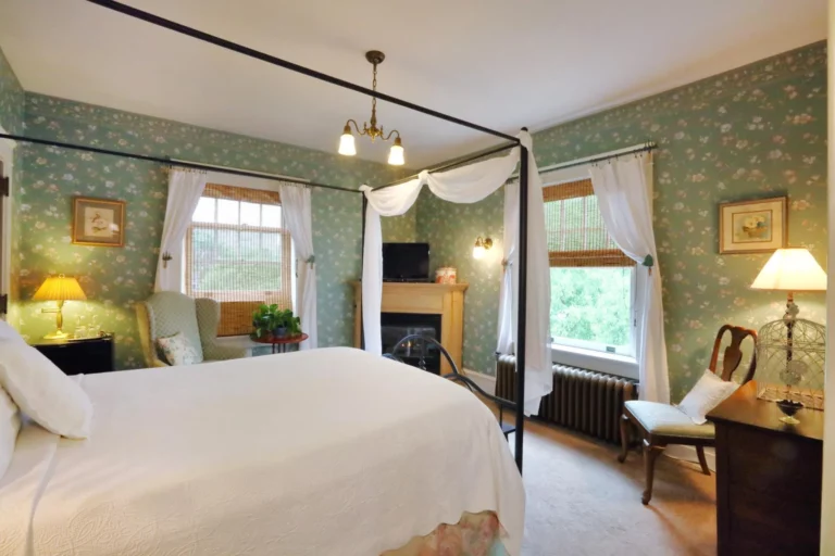 The Antebellum Room decorated with magnolia wallpaper and a plantation-style queen bed