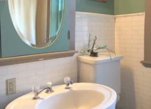 A private bathroom featuring an antique pedestal sink and a one-person whirlpool tub for a relaxing soak