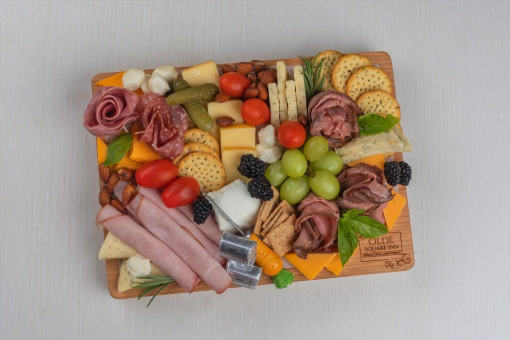 Charcuterie board with meats, cheeses, fruits, chocolates, and nuts from Olde Square Inn